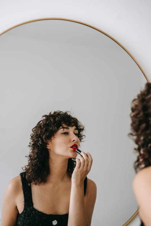 kvinde lægger makeup ved spejl